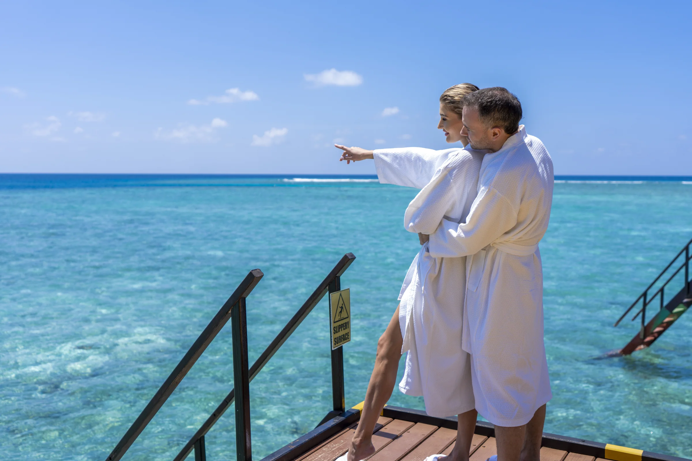 Couple in bathrobes on an overwater deck, Adaaran Club Rannalhi