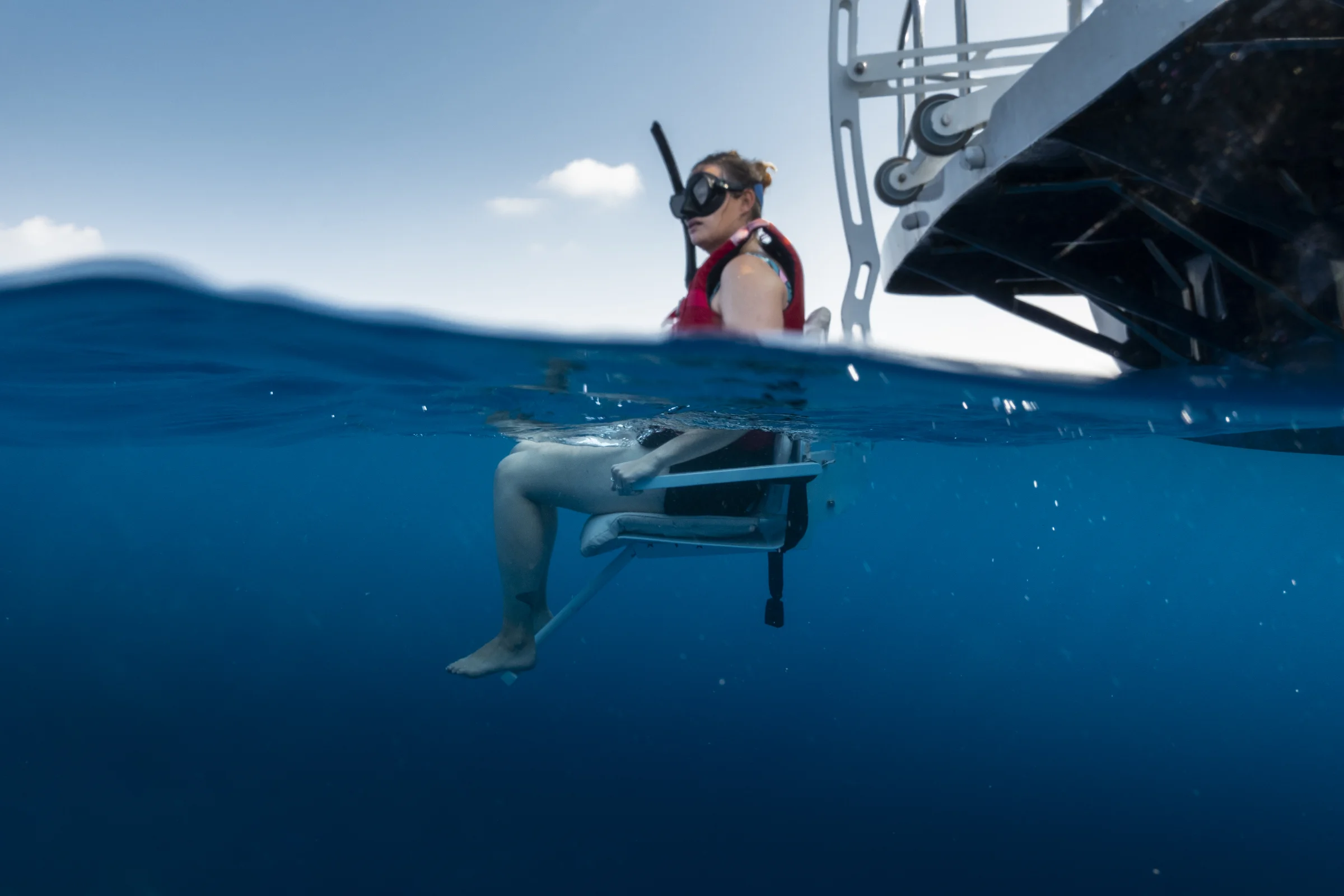 Snorkeller using an accessible boat lift seat, Amilla Maldives
