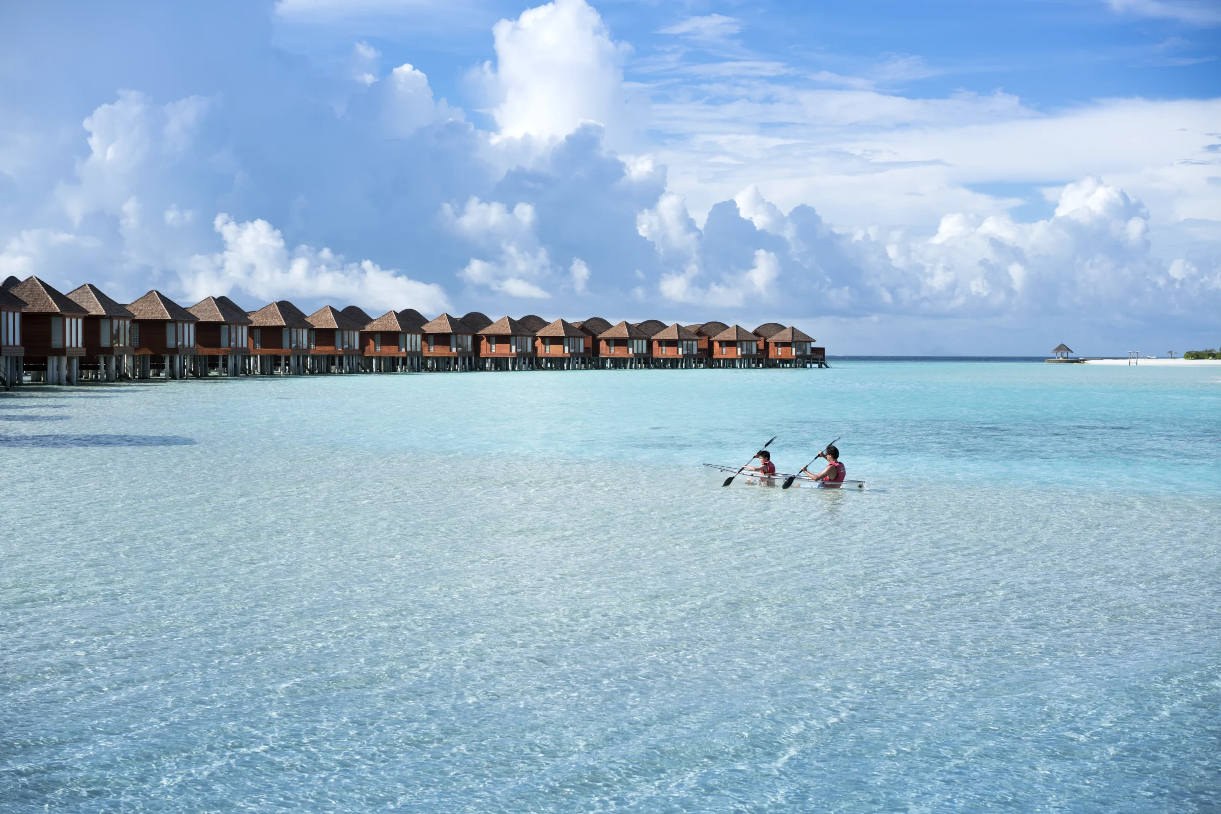 Couple kayaking in the lagoon beside the overwater villas, Anantara Dhigu
