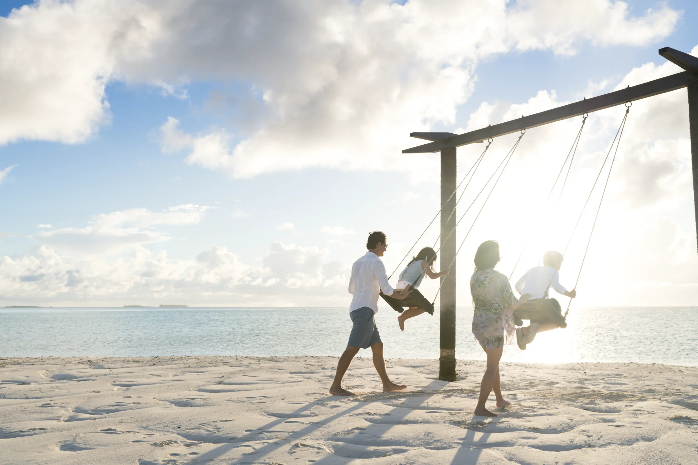 Family on beach swings, Anantara Dhigu