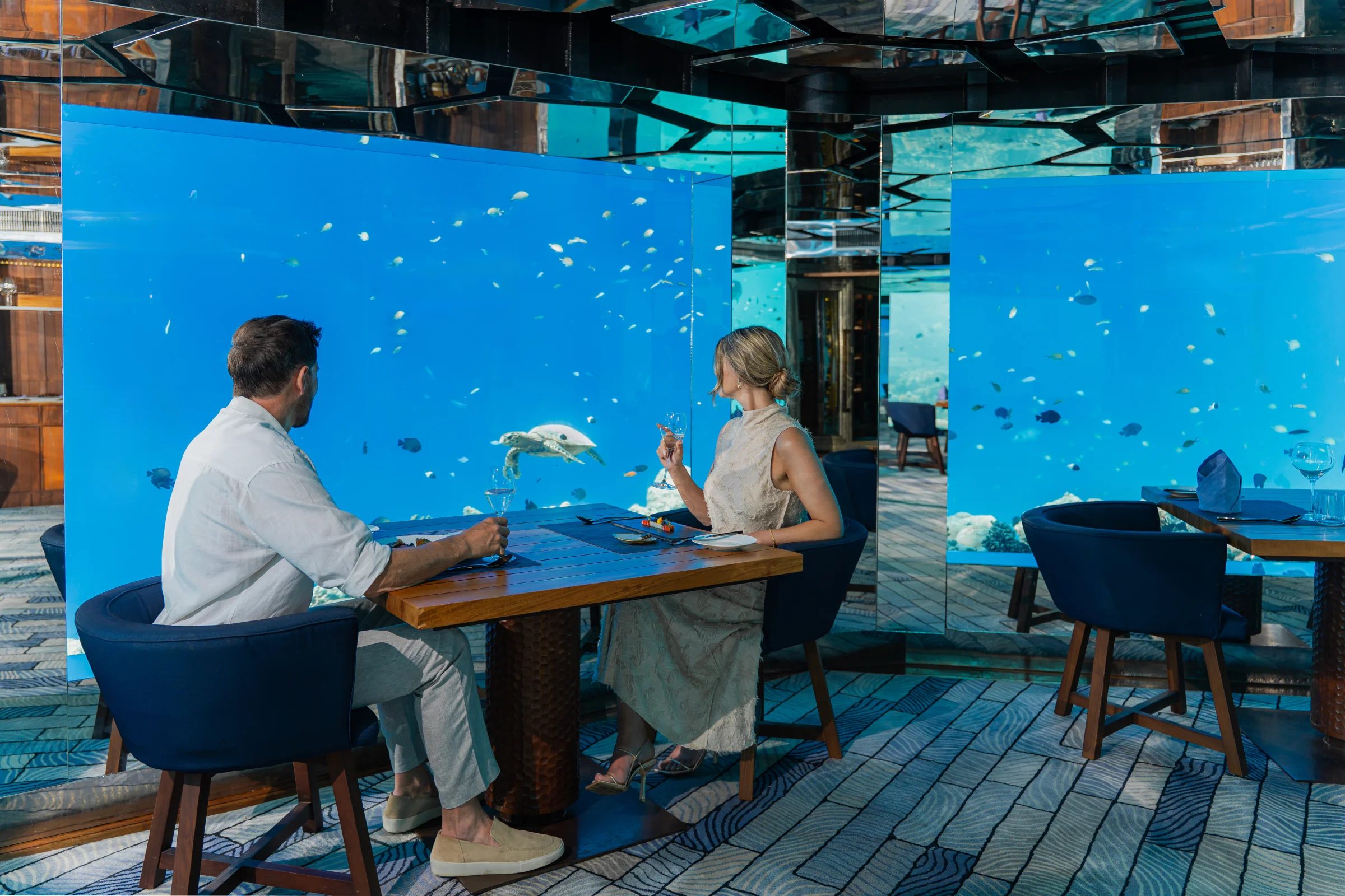 Couple dining at SEA underwater restaurant, Anantara Kihavah