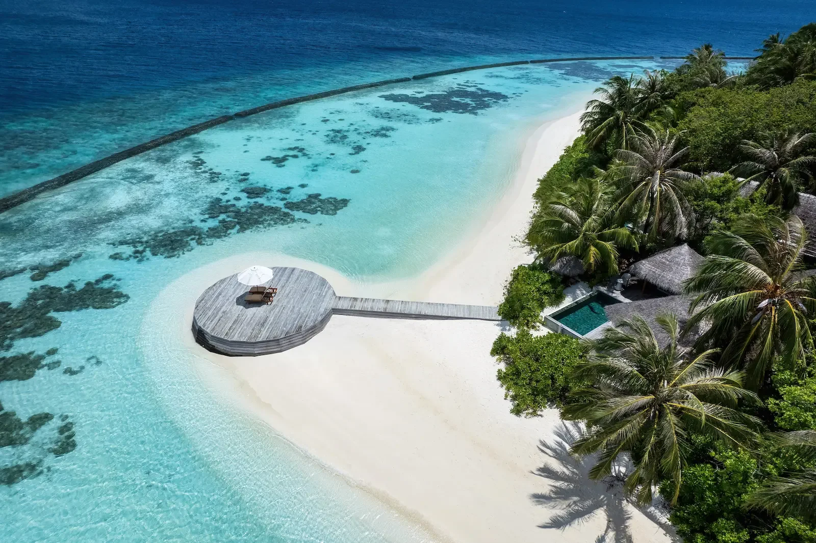 Aerial view of a deck over the lagoon beside the beach, Baros Maldives