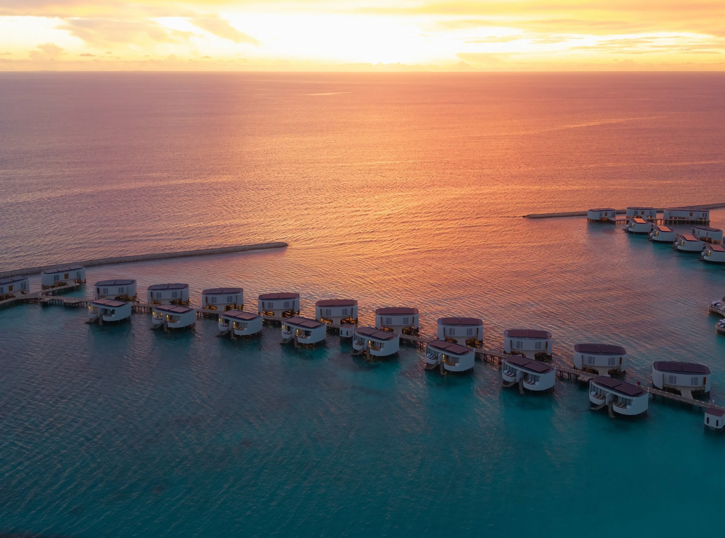 Overwater villas at sunset from above, Centara Grand Lagoon Maldives