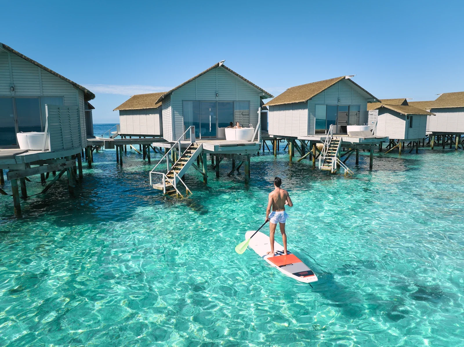 Paddleboarding beside the overwater villas, Centara Ras Fushi