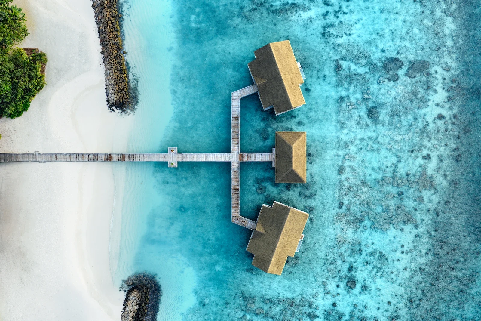 Top-down view of overwater pavilions on the lagoon, Joali Maldives