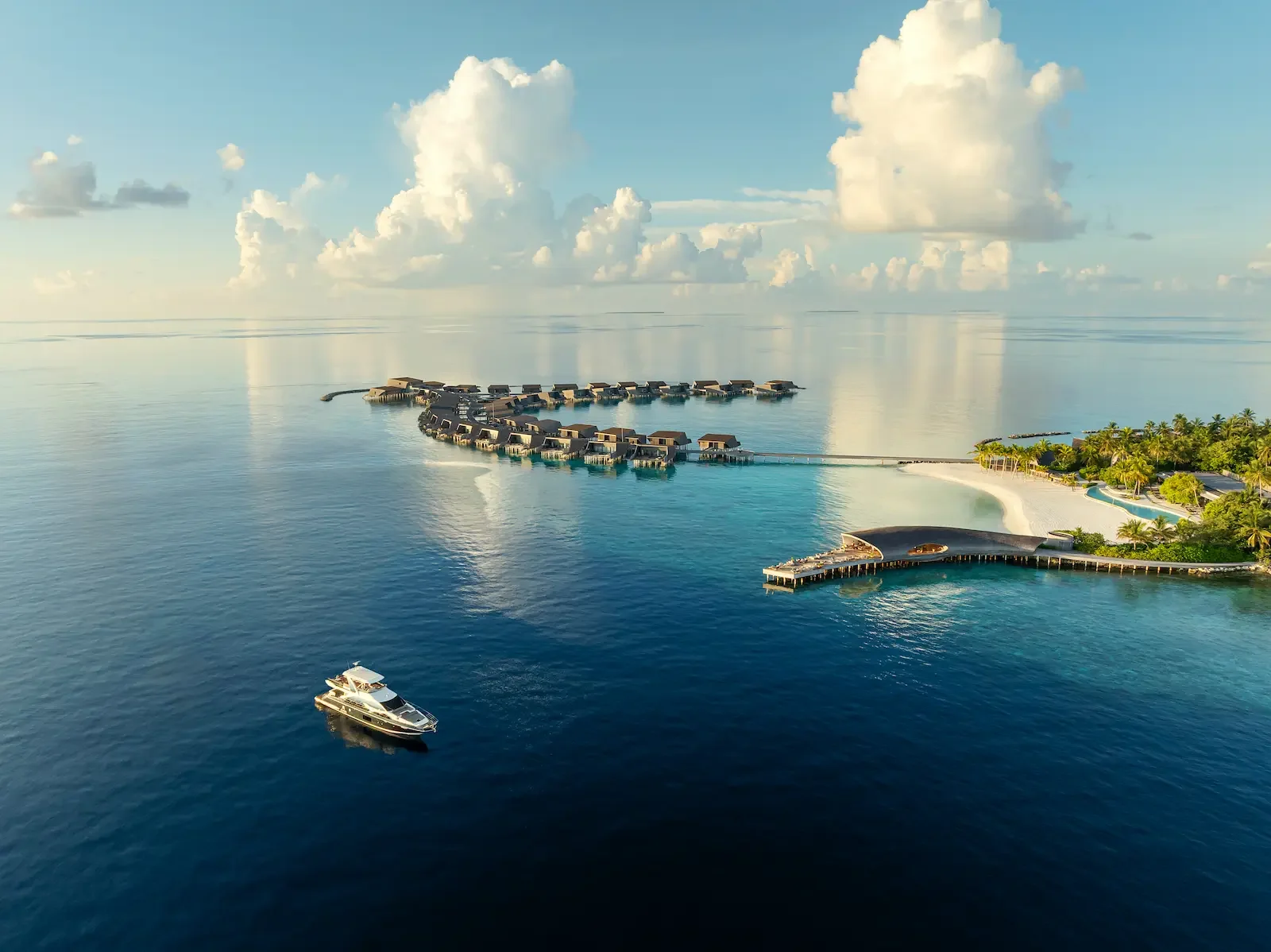 Aerial view of the water villas and a yacht, The St Regis Maldives Vommuli