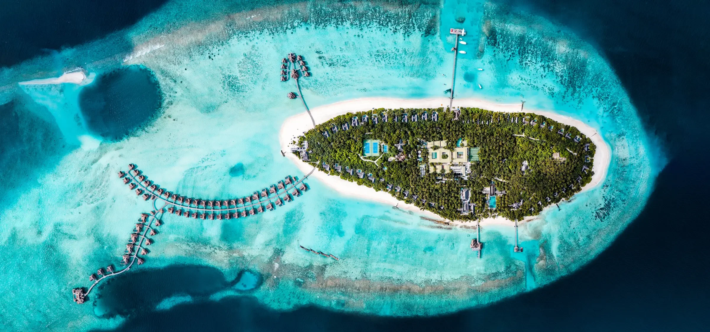 Aerial view of the island, its house reef and water villas, Vakkaru Maldives