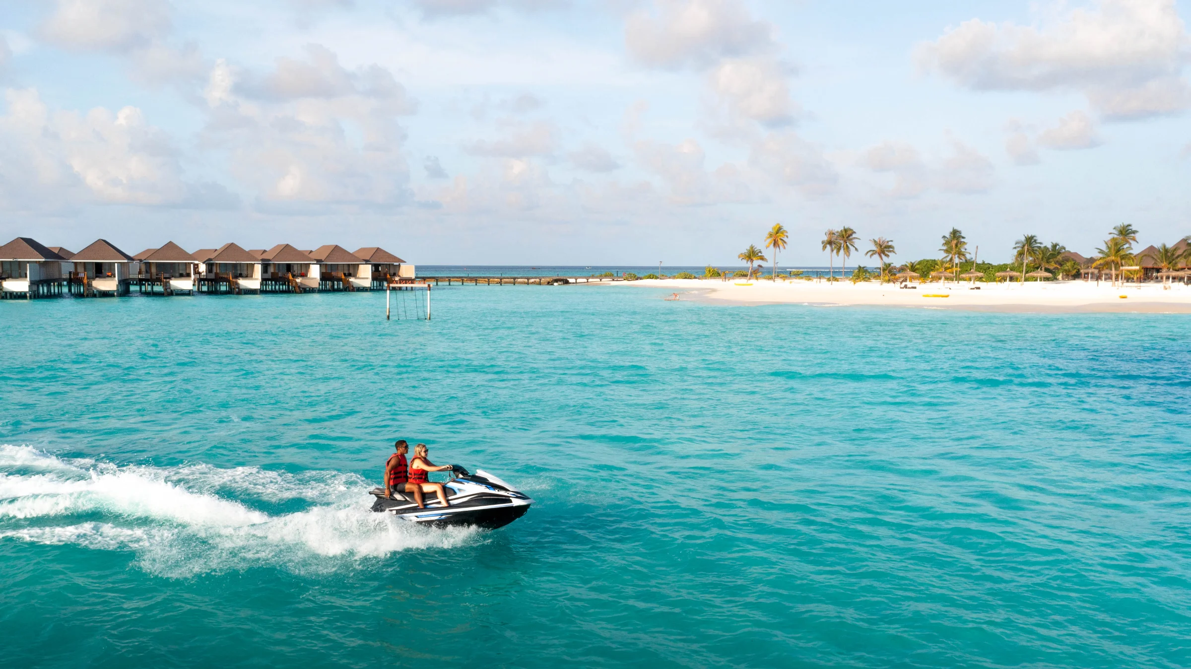 Jet ski in front of the water villas, Brennia Kottefaru